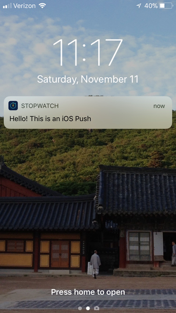 iPhoneのホーム画面に表示されるStopwatchのプッシュメッセージの例:「こんにちは。これは iOS プッシュ通知です。」